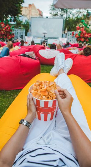 laying eating snacks watching movie at open air cinema. summer time. leisure activities